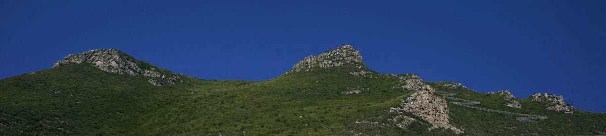 HD Printing Our full range of products. Hilly landscape with rocky outcrops under a clear blue sky. 